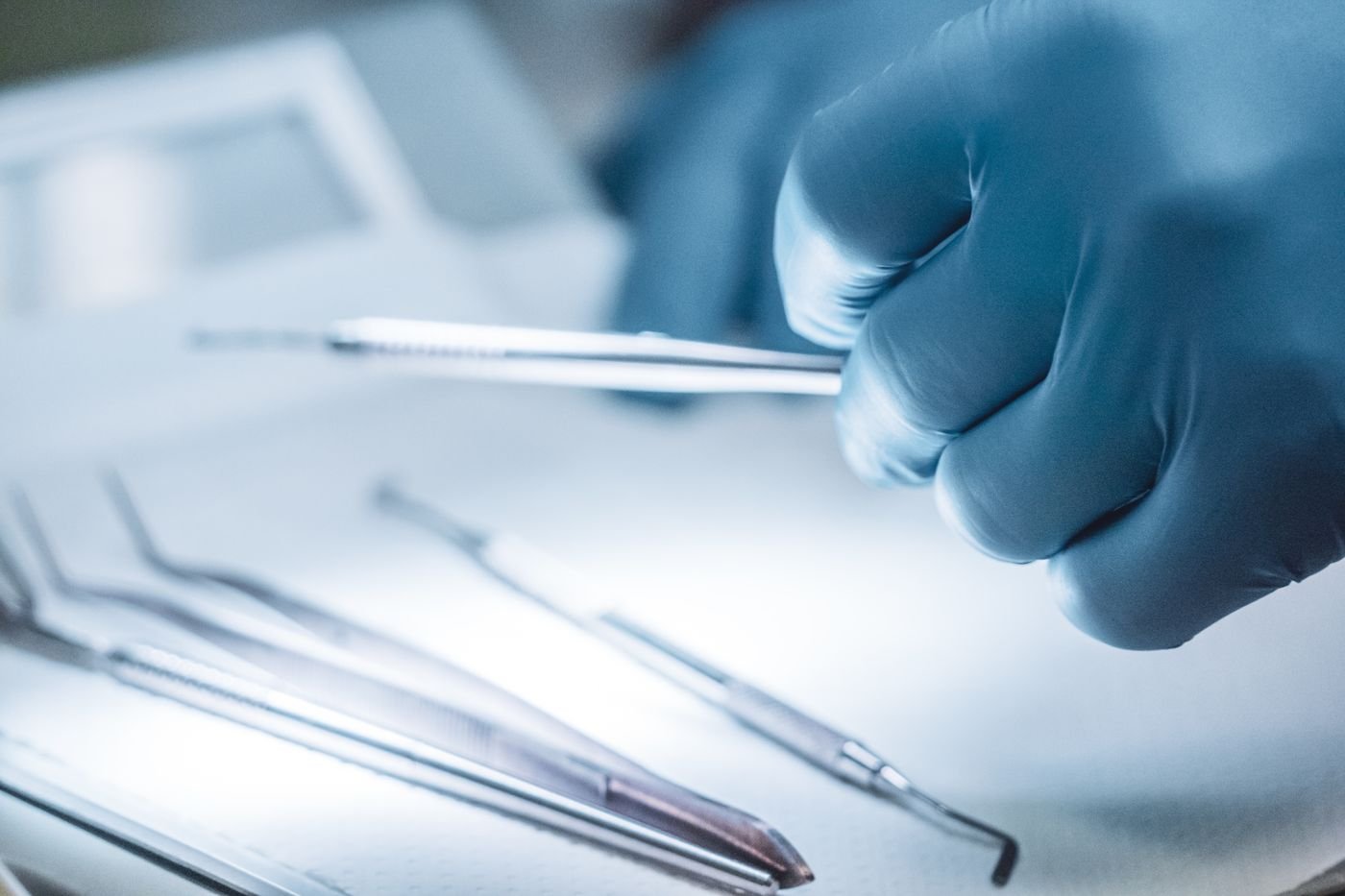 Surgeon's gloved hands holding sterile surgical instruments