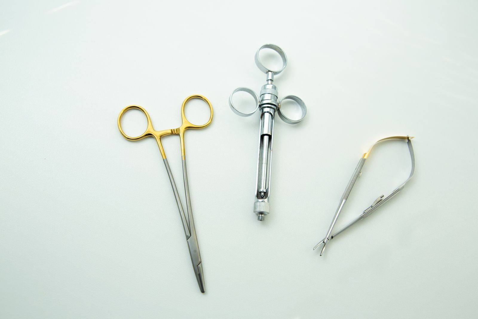 Close-up of sterile surgical instruments including forceps and scissors on a clean surface