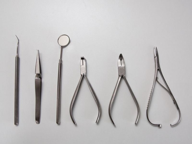 A row of sterile surgical and dental instruments laid out for inspection